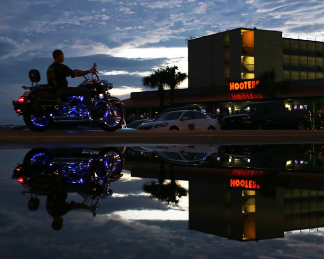 A motorcycle drives along Front Beach Road at sunset in Panama City Beach on Wednesday.