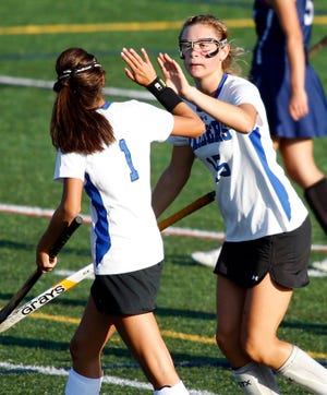 Dover-Sherborn's Mallory Stewart (right) gets a high-five from Abbey Gannon after scoring a goal during the Raiders' 3-2 win over Medway on Wednesday.