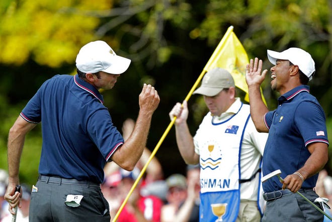 United States' Matt Kuchar, left, and teammate Tiger Woods celebrate Kuchar's birdie on the first hole during a four-ball match against the International team at the Presidents Cup golf tournament at Muirfield Village Golf Club Thursday, Oct. 3, 2013, in Dublin, Ohio. (AP Photo/Jay LaPrete)