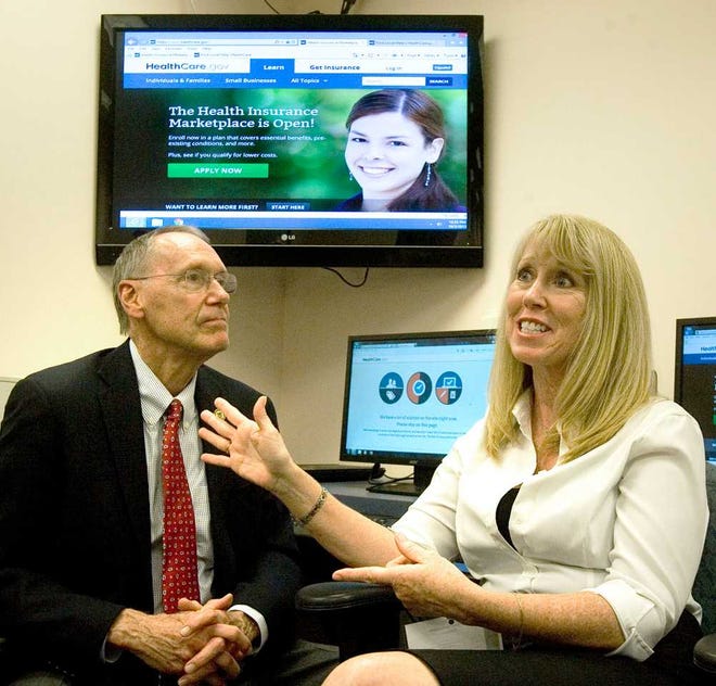 Topeka Mayor Larry Wolgast, left, met with Health Insurance Marketplace Navigator Paige Ashley, right, Thursday afternoon at the Topeka Shawnee County Public Library, to walk him through the same process consumers will go through as they look for health coverage in the Health Insurance Marketplace.