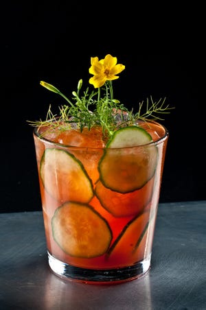 Scott Beattie, author of "Artisanal Cocktails," garnishes his Pimm's Cup with a graceful Lemon Gem marigold. Like the local, organic cucumbers in the drink, the marigold is edible.