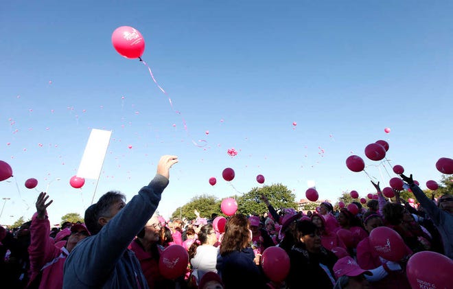 At top, Verleen Karney celebrates surviving cancer for 10 years during the Susan G. Komen Race for the Cure on Saturday in downtown Lubbock. In the inset photo, Ariel Baker, left, walks with Jasmine Willis and her dog Daisy during the event. Above, cancer survivor Barbara Chenault, left, releases a balloon representing her year and a half surviving cancer.