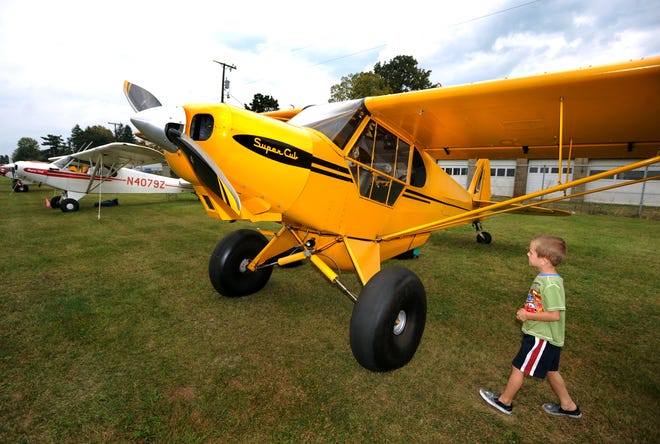 Henry Pritchard, 5 of Dover, checks out a Piper Super Cub bush plane owned by Lou Furlong of Atlanta, GA Friday at Harry Clever Field in New Philadelphia as planes begin arriving for the Ohio Bush Planes Fly-In Pancake Breakfast.