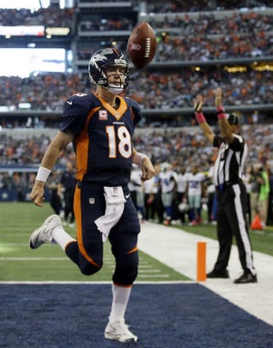 Denver's Peyton Manning tosses the ball away after running for a touchdown in the second quarter. He also passed for four scores as the Broncos stayed unbeaten.