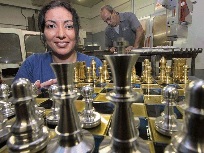 Maggie Morgan, owner of Magga Products,displays metal chess pieces.