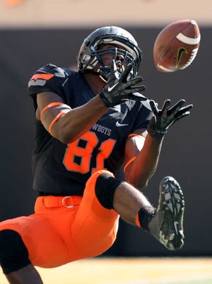Oklahoma State wide receiver Jhajuan Seales catches a 43-yard pass from quarterback J.W. Walsh during the first half of an NCAA college football game against Kansas State in Stillwater, Okla., Saturday, Oct. 5, 2013. (AP Photo/Brody Schmidt)