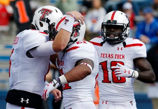 Texas Tech quarterback Baker Mayfield, left, celebrates a touchdown with running back DeAndre Washington (21) and wide receiver Eric Ward (18) during the second half of an NCAA college football game against Kansas in Lawrence, Kan., Saturday, Oct. 5, 2013.