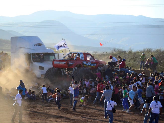 In this Saturday, Oct. 5, 2013, photo, people flee as an out-of-control monster truck plows through a crowd of spectators at an air show in Chihuahua, Mexico. According to authorities, the accident killed at least eight people and hurt at least 80 others, dozens seriously. (AP Photo/Courtesy El Diario de Chihuahua)