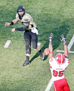 Wake Forest quarterback Tanner Price throws a pass over N.C. State's Art Norman on Saturday.