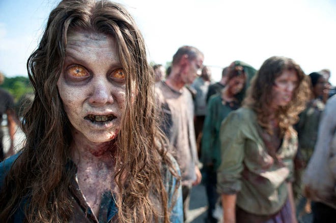 In this image released by AMC, zombies appear in a scene from the second season of the AMC original series, "The Walking Dead," in Senoia, Ga. The series' fourth season premieres on Oct. 13. Crews have been filming the new episodes in Georgia, but they keep locations of future episodes closely-guarded secrets until the shows air. In Grantville, Ga., the town's ruins were featured prominently last season.  In nearby Senoia, many scenes are filmed in the historic downtown area, transforming into the fictional town of Woodbury for the show.  (AP Photo/AMC, Gene Page) NO SALES