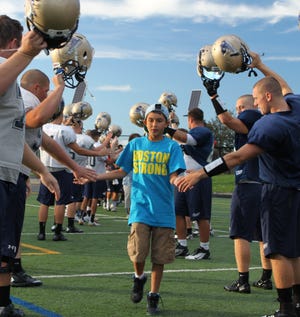 Michael Hebert, 11, of Marshfield has a "signing day" with the Mass. Maritime Buccaneers football team on Sept. 6, part of the Team IMPACT program that connects sick children with collegiate sports teams.