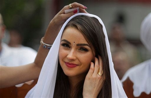 During a visit to the Tihar Jail in New Delhi, India, on Sept. 30, Miss Universe -- Olivia Culpo of Cranston, R.I. -- watches a performance by inmates as designer Sanjana Jon adjusts her veil. Tihar is a massive complex of nine jails in New Delhi, one of the largest incarceration facilities in South Asia.