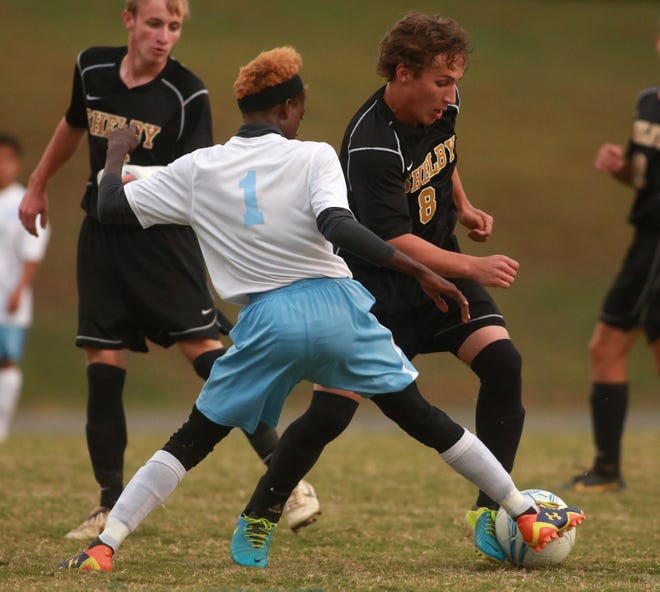 Shelby's Ben Gold looks to dribble around Burns' Von Littlejohn in the Golden Lions' 3-0 win Tuesday at Ron Greene Stadium.