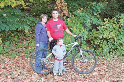 Derek Atkinson of Tecumseh, pictured with his wife, Kim, and 3-year-old son, Josiah, is planning to bicycle across Michigan this weekend to promote his family’s efforts to adopt a baby.