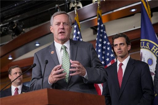 Rep. Mark Meadows, R-N.C, center, Rep. Tom Graves, R-Ga., right, and other conservative Republicans discuss their goal of obstructing the Affordable Care Act, popularly known as Obamacare, as part of a strategy to pass legislation to fund the government, on Capitol Hill in Washington, Thursday, Sept. 19, 2013. (AP Photo/J. Scott Applewhite)