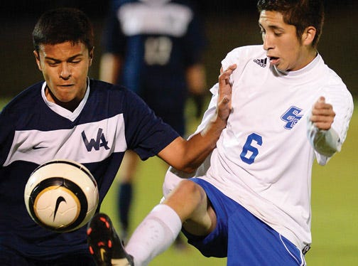 Western Alamance's Robert Burns, left, and Eastern Guilford's Edgar Santos jockey for position during Wednesday night's Mid-State 3-A Conference boys' soccer game.