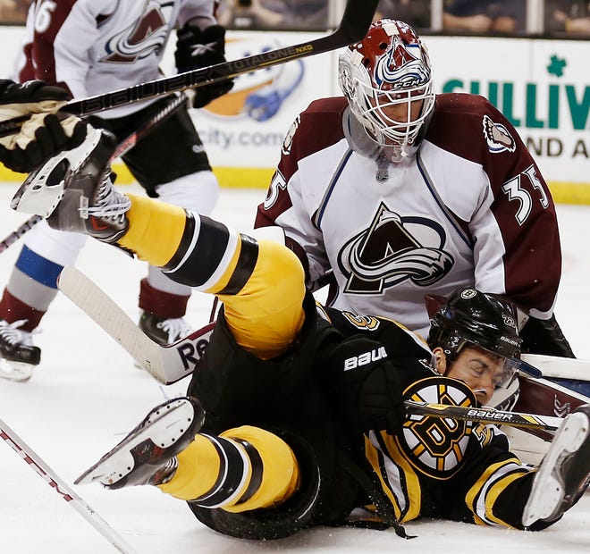 Chris Kelly is sent to the ice in front of Avalanche goalie Jean-Sebastien Giguere during the second period of the Bruins' 2-0 loss to Colorado at TD Garden on Thursday night.