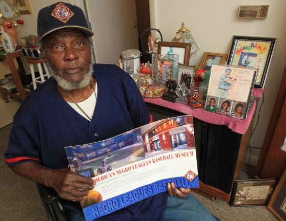 Former Negro League player Carl 'Satch' Forney shows off some items he has saved over the years at his home Friday afternoon at the Katherine Booth Apartments on Union Road.