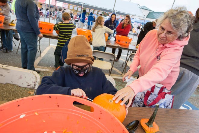 Kacie Desautels, 9 of Lebanon, Maine, and great-grandmother Doloris Lentz enjoy cutting a jack-o-lantern out of a pumpkin in Somersworth Saturday.