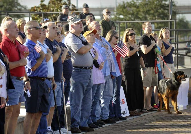 Photos by Will.Dickey@Jacksonville.com Veterans and supporters sing the national anthem during a rally to support veterans Sunday at the Veterans Memorial Wall in Jacksonville. The rally was held at the same time as other rallies nationwide to protest the closing of memorials.