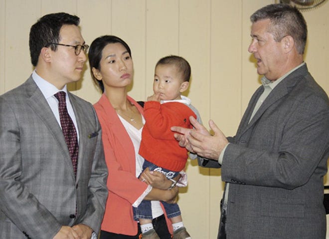 State Treasurer Dan Rutherford, right, speaks with Steve Kim at a press conference Monday afternoon at the Elks Lodge. Rutherford is running for governor and Steve Kim is his lieutenant governor running mate. In back are Kim’s wife, Misuk, and son, Lincoln.