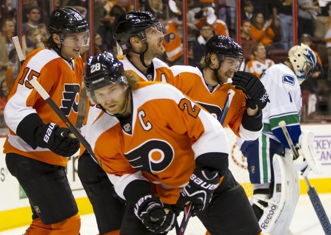 The Flyers' Tye McGinn (left) heads back with teammates Claude Giroux (foreground), Mark Streit (center top) and Jakub Voracek after McGinn scored his second goal against the Canucks during the second period Tuesday in Philadelphia.