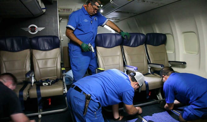 In this Sept. 23 photo, Southwest Airlines aircraft technicians install newer, skinnier seats on a 737 at the carrier's headquarters in Dallas. Southwest says passengers will have the same amount of legroom even though the new seats allow for another row onboard.