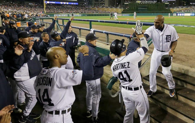 Detroit Tigers' Torii Hunter is greeted by Victor Martinez (41) after scoring on single by Miguel Cabrera in the second inning during Game 4 of the American League baseball championship series Wednesday, Oct. 16, 2013, in Detroit. (AP Photo/Matt Slocum)