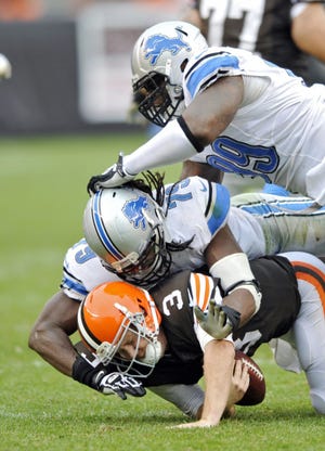 Browns quarterback Brandon Weeden is sacked by Lions defensive end Willie Young.