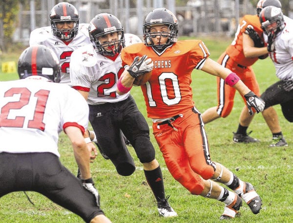 MHS running back Casey Tucker gets by two North Quincy defenders and has one more to beat.