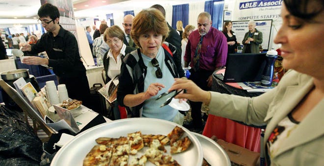 D. Meredith Morris, right, director of human services at Venus de Milo, serves food to visitors at the expo.