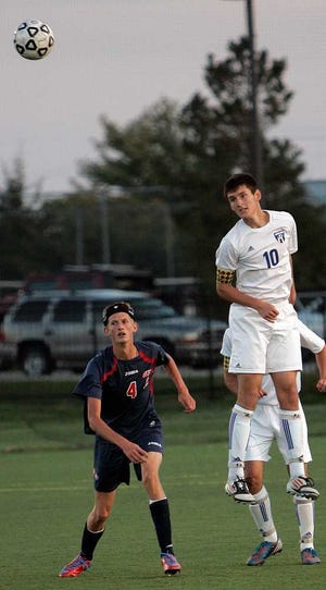 Washburn Rural's Alec Berryman (right) heads the ball away from Seaman's Jake Weller during the first half of Thursday night's match at Washburn Rural.