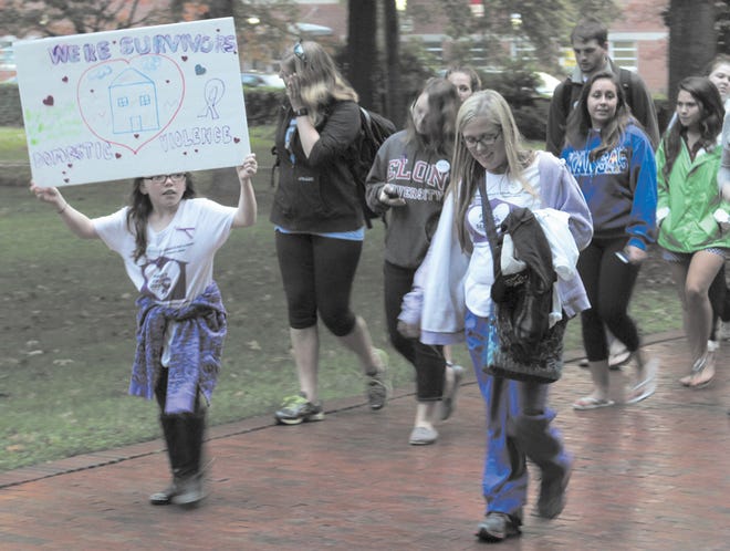 Participants in “Walk a Mile in Her Shoes” proceed around the campus of Elon University on Thursday evening to raise awareness of domestic violence.