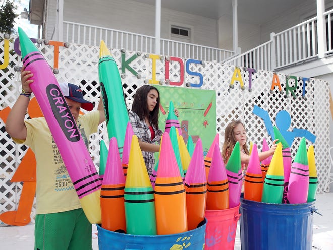 Jace Griffin (from left), 8, Maya Bourgeois, 11, and Zoe Mason, 7, set up cans of inflatable crayons Friday morning for today’s Just Kids at Art, St. Matthew’s Episcopal School’s annual fundraiser. The free event goes from 9 a.m. to 4 p.m. today on the school grounds at 243 Barrow Street, rain or shine. The fundraiser lets children and their families explore their creative sides with hands-on projects.