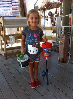Isabella Stanley, 5 ½, of Tennessee came walking up with a fish in a bucket to weigh in at the Destin Fishing Rodeo. She, like all children who weigh in a fish at the rodeo receive a free rod and reel as well as a certificate recording their catch.