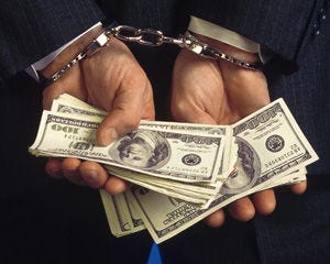 Handcuffed businessman holding cash