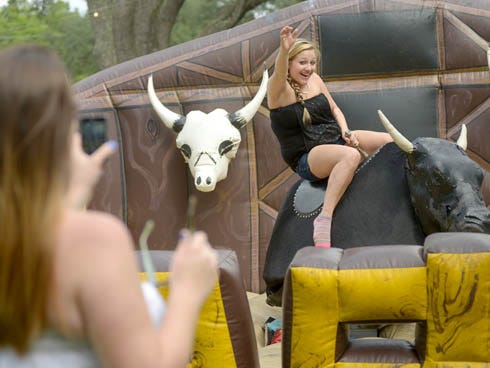 Jennifer Karol of Panama City rides a mechanical bull on Friday at the 37th Annual Boggy Bayou Mullet Festival in Niceville.
