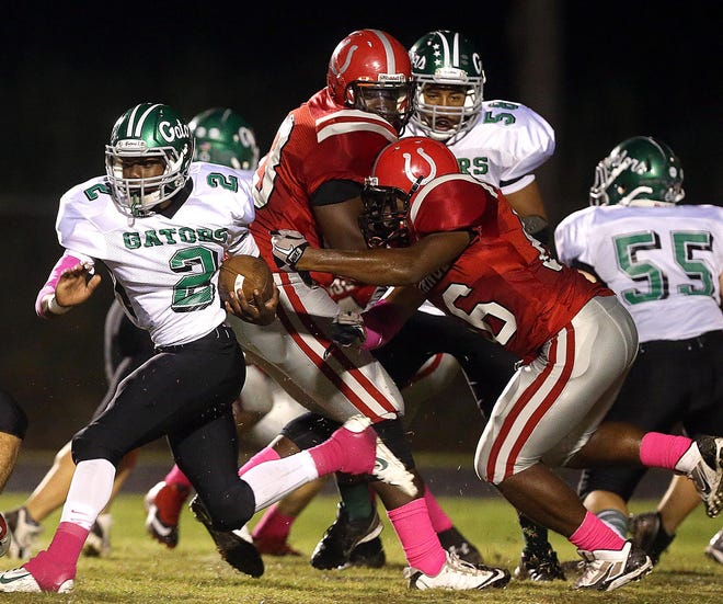 South Terrebonne running back Rodney Carvin (2) tries to escape the fingertips of Assumption's Devin Hadrick Friday.