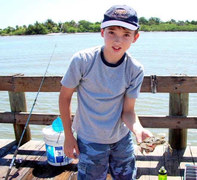Michael Kuhn, of St. Marys, poses for a photo on a fishing trip. Michael was a Boy Scout who showed interest in water sports and outdoor activities. His suicide shocked and devastated his parents.