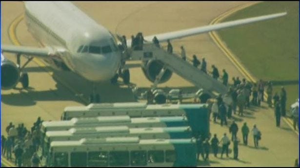 Passengers exit a plane at Charlotte Douglas International Airport on Monday, Oct. 21, 2013.
