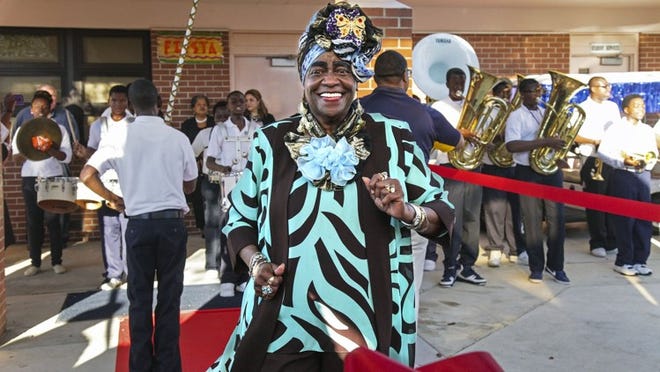 Betty Lou McCray-Wells dances to the beat of the Bear Lakes Middle School marching band at the surprise dedication of the media center in honor of the longtime Palm Beach County educator Monday.