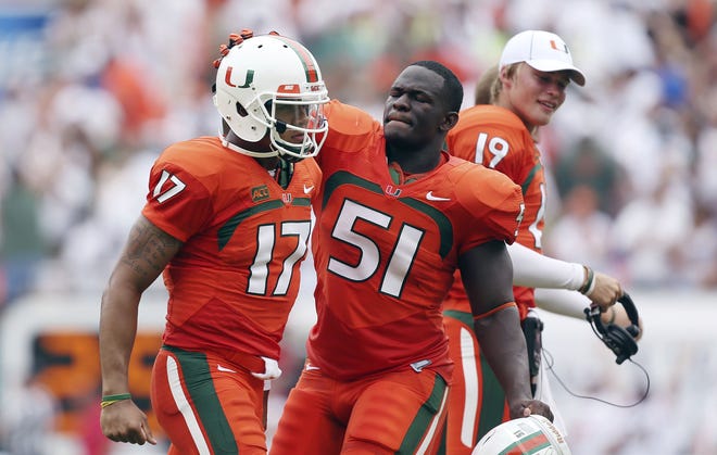 Miami quarterback Stephen Morris (17) and Shayon Green (51) celebrate after a TD during the first half of a NCAA college football game in Miami Gardens against Florida.
