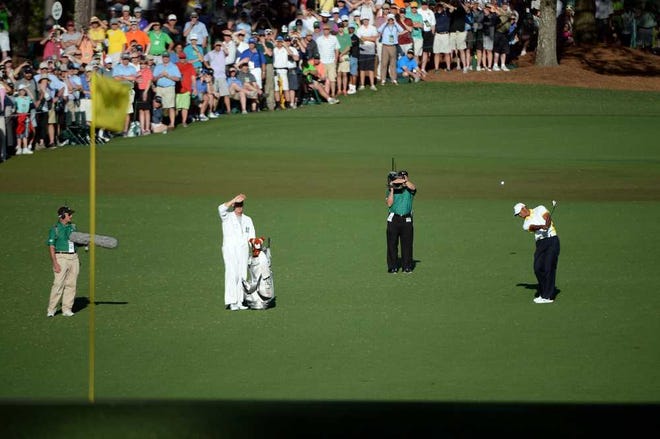 Tiger Woods hits his second approach shot to the 15th green after making a drop during the second round of the 2013 Masters Tournament at Augusta National Golf Club on Friday, April 12, 2013, in Augusta, Ga.
