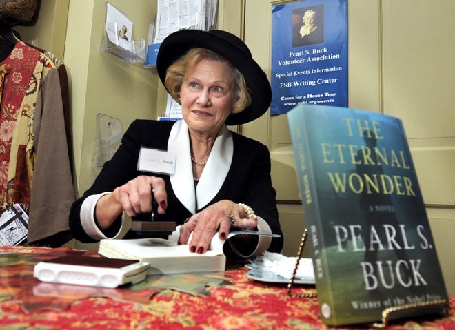 Docent Susie Woodland, portraying Pearl S. Buck, stamps copies of Buck's newly discovered novel during a book release Tuesday at the Pearl S. Buck House in Hilltown on Tuesday. Art Gentile/Staff photographer