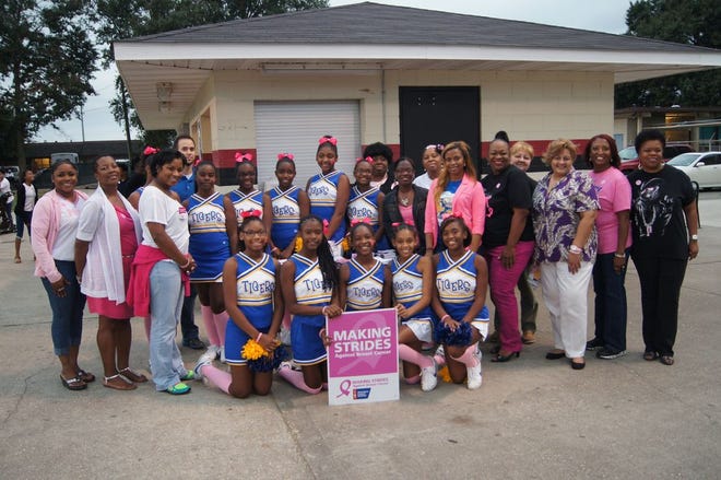 Breast Cancer supporters and Lowery Middle School administration and cheerleaders stand together to raise awareness Thursday at Floyd Boutte Memorial Stadium.