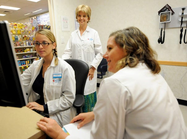 Marlene Wallace (center), manager of the CVS Minute Clinic in the pharmacy's location at 6901 Market St., watches as Amanda Baker (left) and new hire Michaela Murphy work through an orientation exercise Tuesday Oct. 22, 2013.