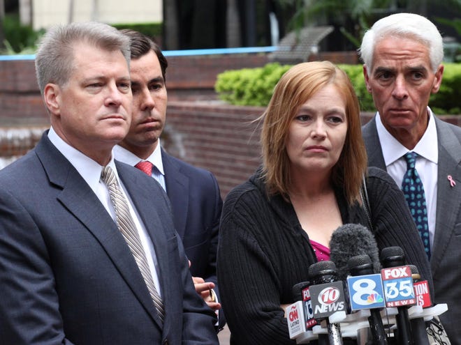 Morgan & Morgan attorneys David Henry, left, Matt Morgan and former Florida Gov. Charlie Crist surround Tricia Norman as he answers a question during a press conference in Tampa Thursday.