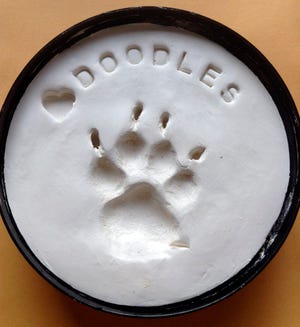 This September 2013 image provided by Patricia Cassidy shows an impression of her dog Doodles’ paw print. Doodles is believed to be one of 580 dogs in the U.S. that have died in the past six years from eating pet jerky from China. Baffled by the cause and seeing another surge in illnesses, the Food and Drug Administration reached out to owners and veterinarians Tuesday to help it find the poison behind the sickening of at least 3,600 dogs and 10 cats since 2007.