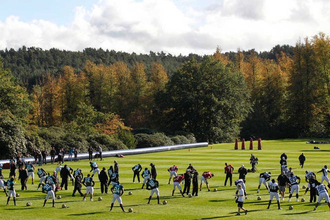 Jacksonville Jaguars players warm up during football practice in Bagshot, England, on Wednesday.