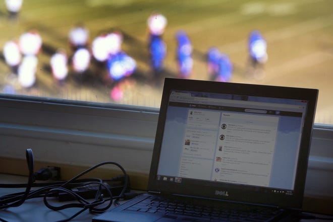 Having a computer screen affixed on Twitter during a local football game is part of the norm for football coverage these days. (Ben Earp / The Star)